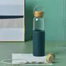 Custom transparent glass water bottle with silicone sleeve and bamboo lid with logo