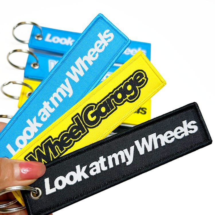 Promotional wholesale custom brand name travel souvenir woven embroidery logo fabric keychains